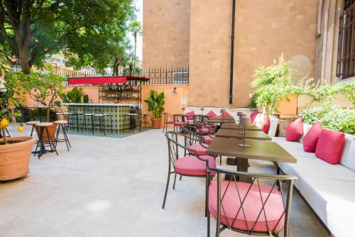 eine Reihe von Tischen und Stühlen auf einer Terrasse in der Unterkunft Hotiday Roma Borghese in Rom