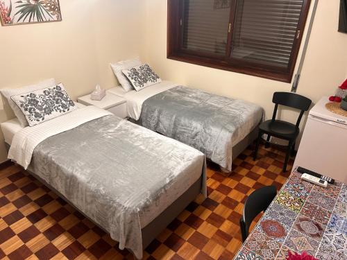 une chambre avec deux lits, une table et une chaise dans l'établissement Maia Oporto Suites, à Maia