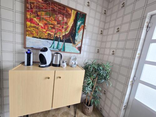 a painting on a wall above a cabinet in a bathroom at Dias de sol in Fuzeta