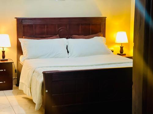 Una cama con cabecero de madera en un dormitorio. en Zuri home 2, en Kampala