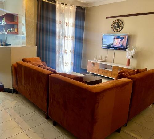 sala de estar con 2 sofás de cuero marrón en Zuri home 2, en Kampala