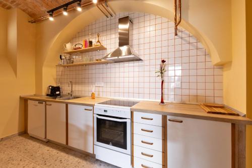 a kitchen with white appliances and an arched wall at Apartment Arc 23 in Celje