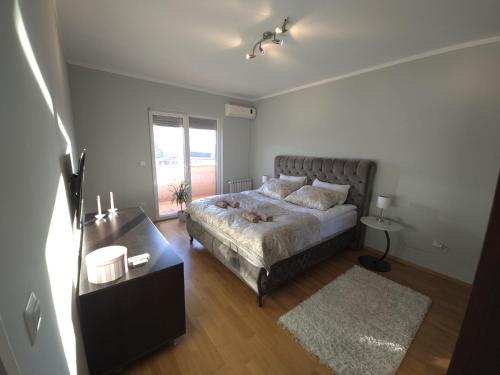 a bedroom with a bed and a table and a window at TerraLuxe Sarajevo in Sarajevo