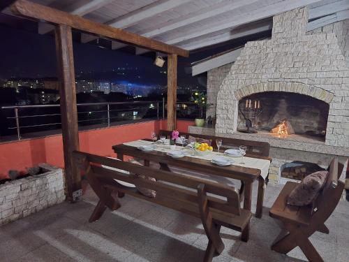 a dining room with a stone fireplace with a table and chairs at TerraLuxe Sarajevo in Sarajevo