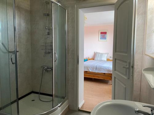 a bathroom with a shower and a bedroom with a bed at Райска тишина in Zlatitsa