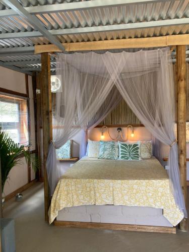a bedroom with a bed with a canopy at Emelios Lodge Océan View in Port Mathurin