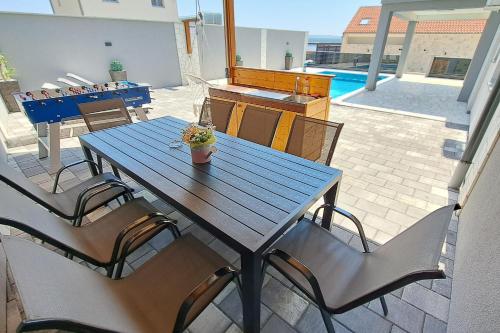 ein Holztisch und Stühle auf einer Terrasse in der Unterkunft Family friendly house with a swimming pool Maslenica, Novigrad - 24641 in Maslenica