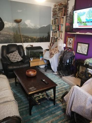 a living room with a couch and a table at Guest house in rear garden in Eltham