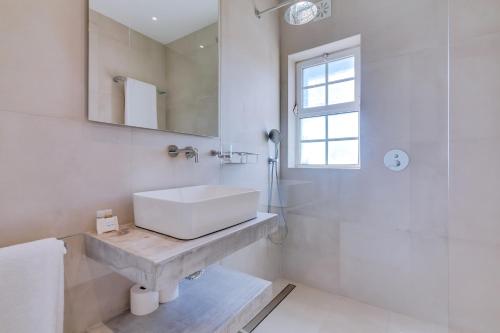 a white bathroom with a sink and a mirror at Casa Nuria com 4 quartos, piscina e churrasco em Vale do Lobo in Almancil