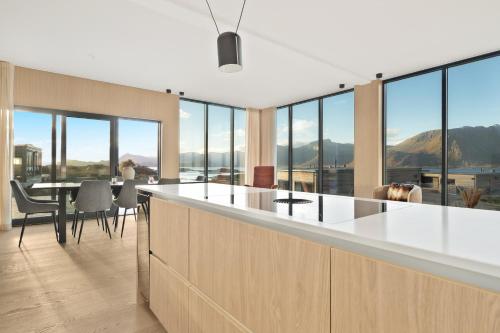 an open kitchen with a table and chairs and windows at Serene cabin in Lofoten with sauna in Storøya