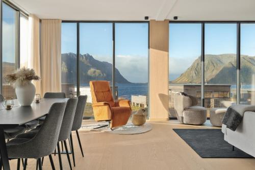 a dining room with views of the ocean and mountains at Serene cabin in Lofoten with sauna in Storøya