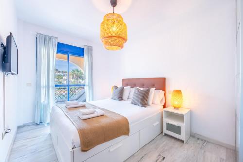 ein weißes Schlafzimmer mit einem Bett und einem Fenster in der Unterkunft VB Albatros - 2BR Apartment Close to the sea in Benalmádena