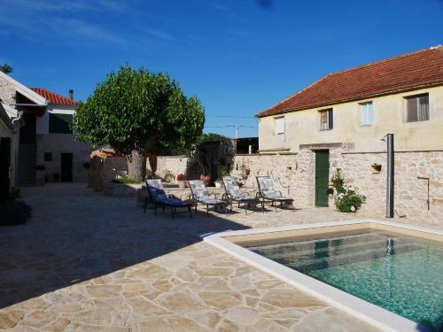 a patio with a swimming pool in front of a building at Villa Didova kuca ZadarVillas in Podlug