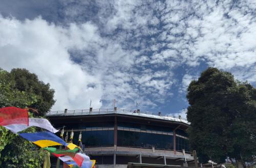 a building with a flag in front of it at Shenga Homestay in Ravangla