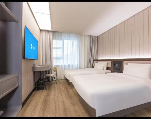 Ένα ή περισσότερα κρεβάτια σε δωμάτιο στο Hanting Hotel Shanghai Fudan University Memorial Road
