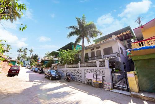 a street with cars parked in front of a building at Peach stay in Mount Ābu