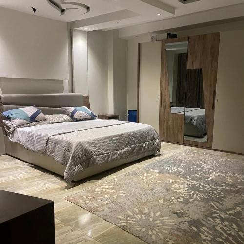een slaapkamer met een bed en een grote spiegel bij نور هوستيل in Riyad