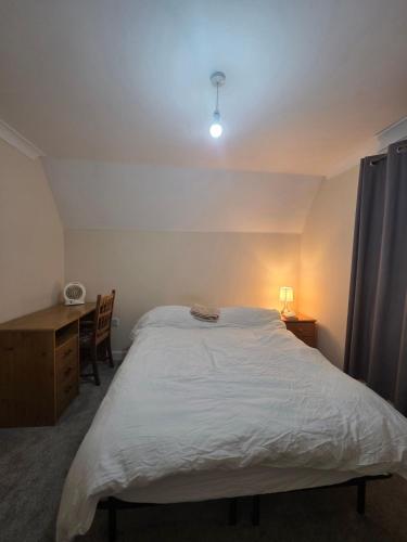 a bedroom with a large white bed and a desk at Cozy Guest Room in Colchester - Perfect for Travelers in Hythe