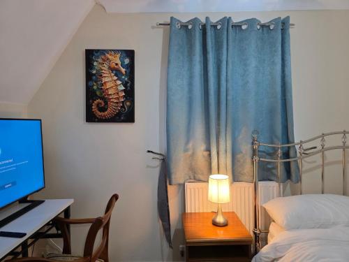 a bedroom with a bed and a desk with a computer at Guest Room in Colchester Hythe in Hythe