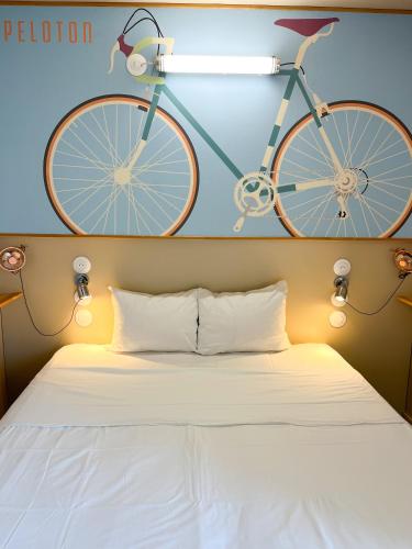a bike hanging on the wall above a bed at The People - Tours in Tours