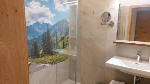 a bathroom with a shower with a view of mountains at Landhotel Häuserl im Wald in Gröbming