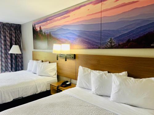 a hotel room with two beds and a painting on the wall at Days Inn by Wyndham Jellico - Tennessee State Line in Jellico