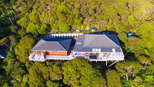 an aerial view of a house in the middle of a forest at Romantic Piha in Piha