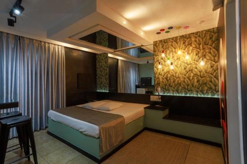 a bedroom with a bed and a painting on the wall at Hotel Motel Paradiso - Carazinho-RS in Caràzinho