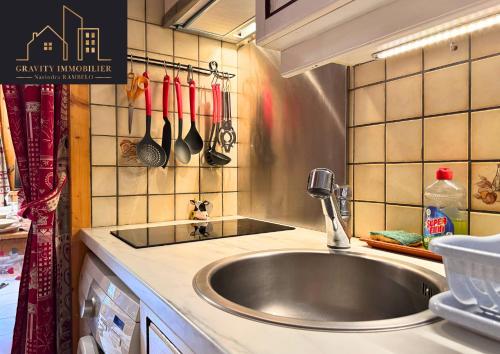 a kitchen with a stainless steel sink and utensils at Chaleureux 2 chambres, Morillon in Morillon