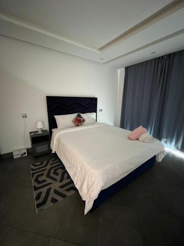 ein Schlafzimmer mit einem großen weißen Bett und einem Fenster in der Unterkunft Appart hôtel las jemelas in Casablanca