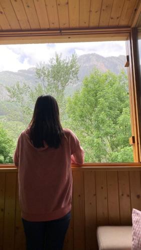 a woman looking out of a window in a cabin at Mira Moleta bienvenidos a Canfranc in Canfranc-Estación