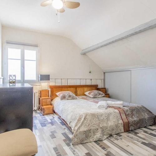 ein Schlafzimmer mit einem großen Bett und einer Kommode darin in der Unterkunft Arhomeplus - Gîte & Séjours Bien-être à Autun in Autun