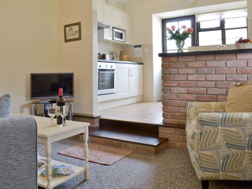 a living room with a brick wall and a table at Ramscliff Cottage in Cheddar