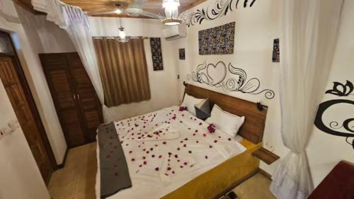 ein Schlafzimmer mit einem Bett mit Blütenblättern drauf in der Unterkunft Maridadi Plaza Apartment in Jambiani