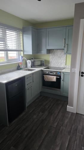 a kitchen with blue cabinets and a stove at Studio apartment in Fishponds in Bristol