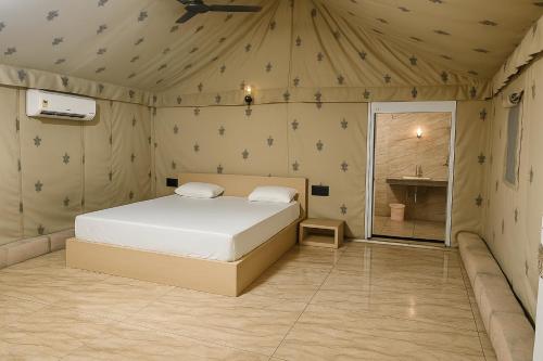 een slaapkamer met een bed in een tent bij The Wilds Villa Gir Jungle Stay with Swimming Pool in Sasan Gir