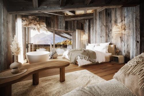 een slaapkamer met 2 bedden en een bad. bij Jufenalm BOHO & Wellnesshotel in Maria Alm am Steinernen Meer