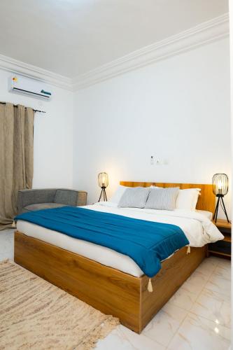 a bedroom with a large bed with blue sheets at Casa Hôtel Résidence in Abidjan