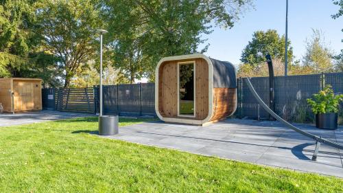 a wooden iguana in a yard with a hose at Inteligentne rubinowe domy z sauną, Sun & Snow in Grzybowo