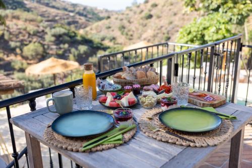 einen Holztisch mit Tellern aus Essen auf dem Balkon in der Unterkunft Casa La Brisa in Arenas