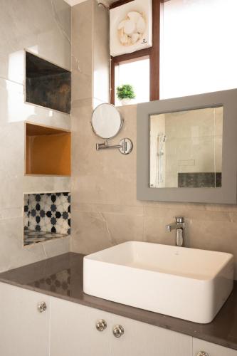 a bathroom with a white sink and a mirror at Yecha House - Mountain & Lake View Retreat, Bhimtal in Bhīm Tāl