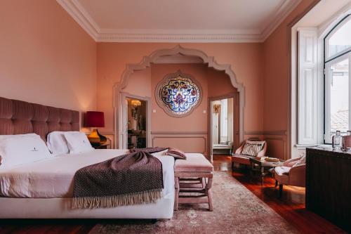 a bedroom with a large bed and a chair at Torel Palace Lisbon in Lisbon