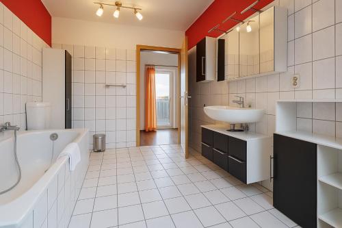 a bathroom with a tub and a sink at Moritz Apartments - Dosborn 7 in Dingelstädt