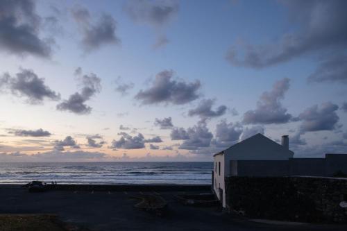 リベイラ・グランデにあるMoinho da Areiaの雲の多い海辺の建物