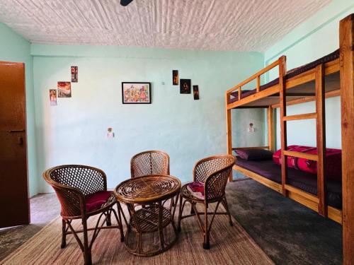 a room with a table and chairs and a bunk bed at Far out Homestay in Hawālbāgh