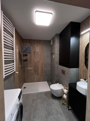 a bathroom with a tub and a toilet and a sink at Apartament Ski &Sun in Świeradów-Zdrój