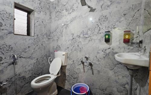 een badkamer met toilet en wastafel bij Hotel Sai Pratham in Shirdi