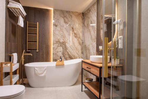 a bathroom with a tub and a sink and a toilet at Hotel Magellan in Bronisławów