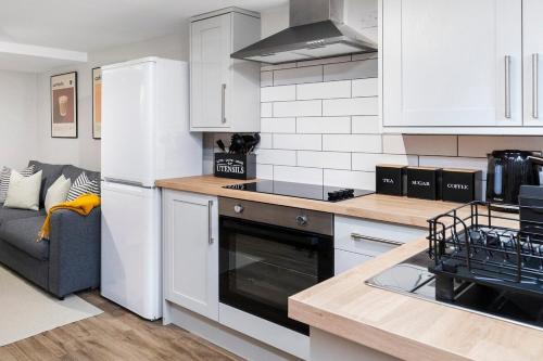 a kitchen with a refrigerator and a stove top oven at Cosy One Bed Apt in Leeds City in Leeds