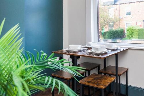 a table and stools in a room with a window at Spacious Two Bed House in Headingley in Headingley